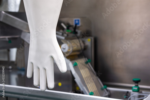 White rubber glove against the background of the in isolator. Drug production in isolation facilities.