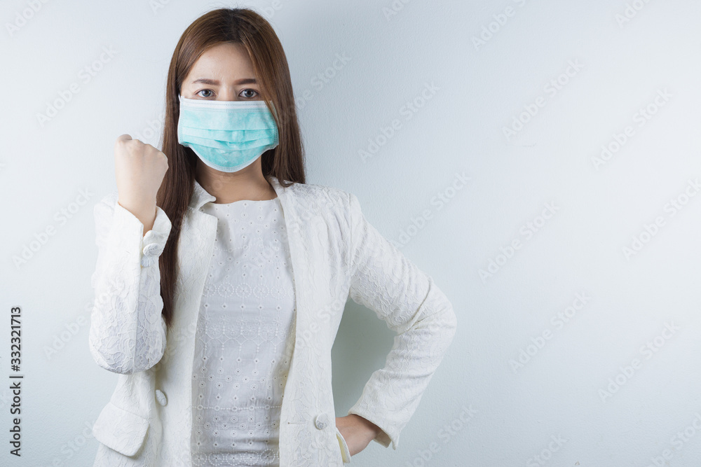 The business girl wearing mask for protecting coronavirus and pm 2.5 and show her hand to fight them. Coronavirus and Air pollution pm 2.5 concept. The business girl wearing mask for protecting coronavirus and pm 2.5 and show her hand to fight them. Coronavirus and Air pollution pm 2.5 concept.