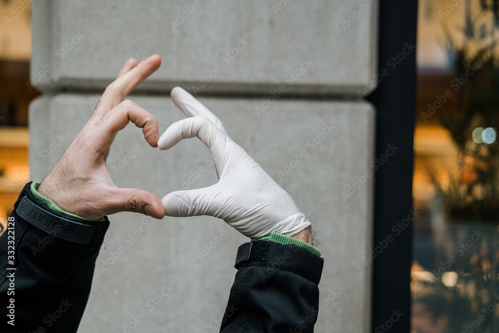 Φωτογραφία Woman hands wearing medical gloves, heart shaped