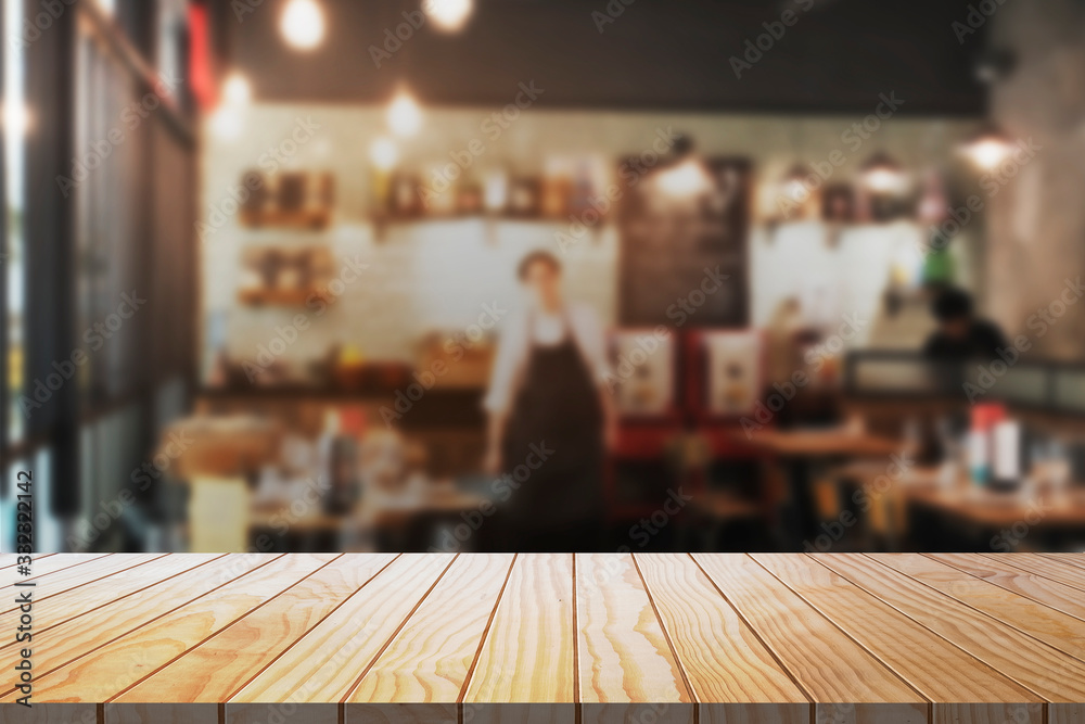 Empty wooden table with blurred restaurant kitchen background