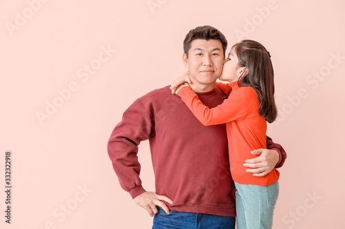 Little Asian girl kissing h...