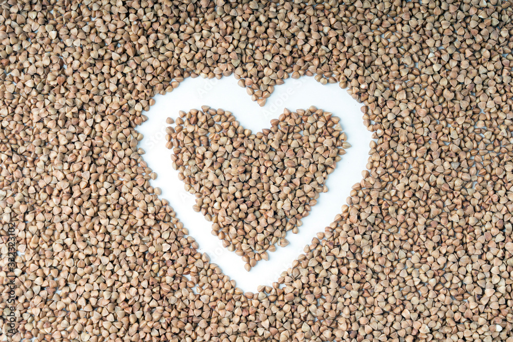 buckwheat heart shape close-up on a white background, selective focus, tinted image buckwheat heart shape close-up on a white background, selective focus, tinted image
