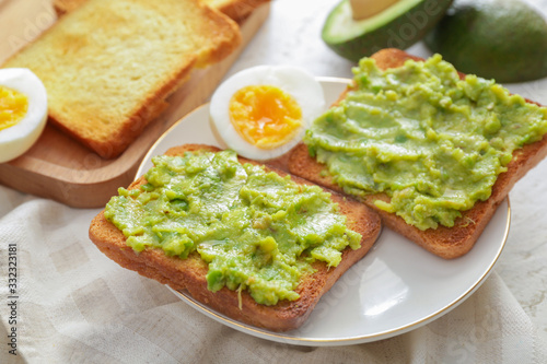 Plate with tasty avocado sandwiches on table