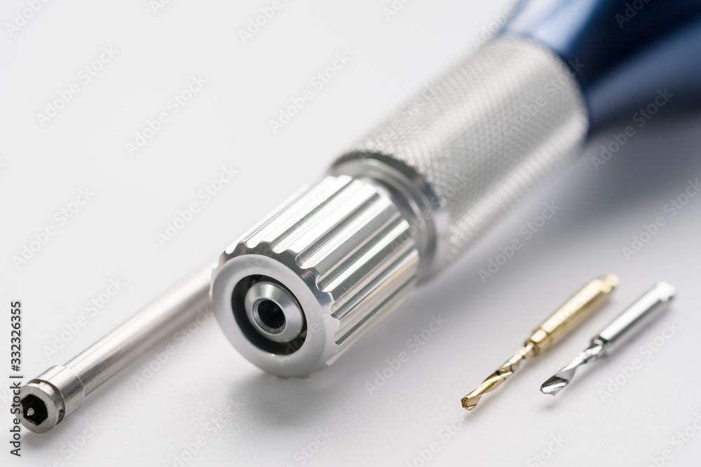 Closeup/ Implant surgical kits/ mini screw/ screw driver/ drilling bits on white background. Closeup/ Implant surgical kits/ mini screw/ screw driver/ drilling bits on white background.