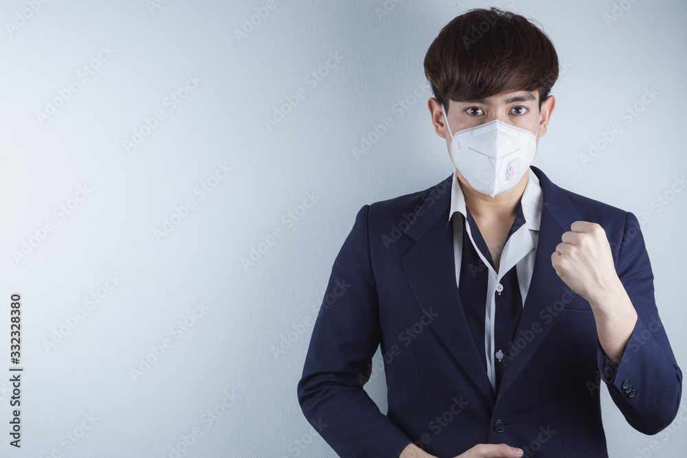 The business man wearing mask for protecting coronavirus and pm 2.5 and show his hand to fight them. Coronavirus and Air pollution pm 2.5 concept. The business man wearing mask for protecting coronavirus and pm 2.5 and show his hand to fight them. Coronavirus and Air pollution pm 2.5 concept.