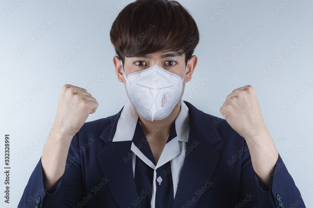 The business man wearing mask for protecting coronavirus and pm 2.5 and show his hand to fight them. Coronavirus and Air pollution pm 2.5 concept. The business man wearing mask for protecting coronavirus and pm 2.5 and show his hand to fight them. Coronavirus and Air pollution pm 2.5 concept.