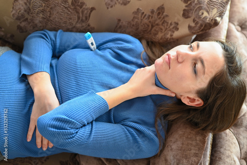 The girl feels suffocation in her throat. close-up. The first signs of coronavirus. The concept of a viral or allergic disease photo