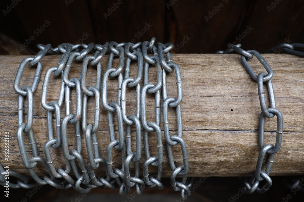 iron chain rings are wrapped around a wooden log