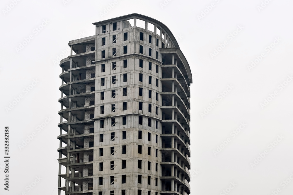 Concrete gray high-rise building partially without external walls. Background