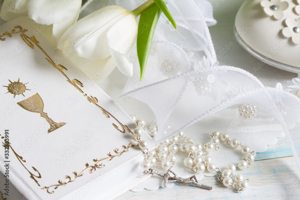 First communion baptism composition with christianity symbols and white tulips First communion baptism composition with christianity symbols and white tulips