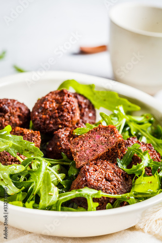 Beetroot Falafel with arugula leaves in a white bowl. Healthy vegan food concept.