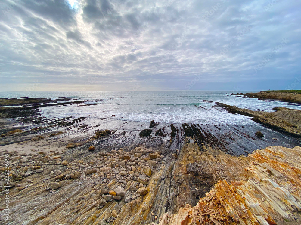 Dynamic picture of low tide seashore , rocks and surreal looking clouds   
