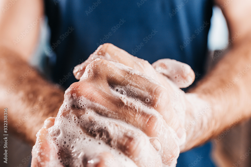 Personal hygiene - thorough hand washing with soap - close-up of male hands in soapy foam