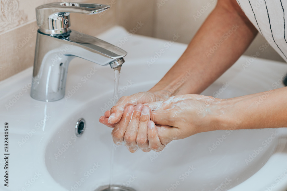 Woman use soap and washing hands under the water tap. Hygiene concept hand detail. Woman use soap and washing hands under the water tap. Hygiene concept hand detail.