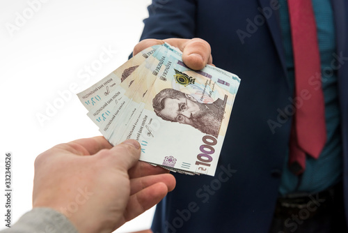 businessman gives or takes a bribe of money. Ukrainian hryvnia, new banknotes of 1000 hryvnia.