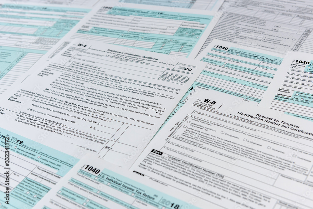 Fototapeta premium Many different usa tax form. w4 w9 and 1040 form for fill in april. Tax time