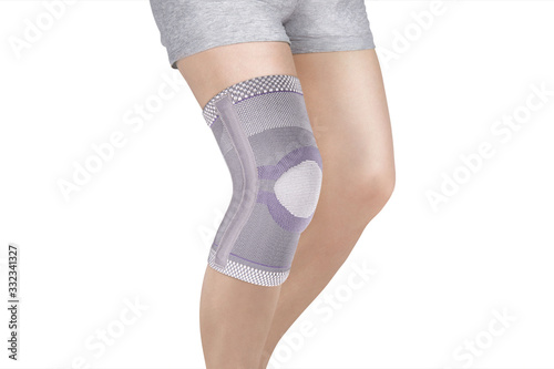 Knee Support Brace on leg isolated on white background. Orthopedic Anatomic Orthosis. Braces for knee fixation, injuries and pain. Orthotics. Foot orthosis. Knee Joint Bandage Sleeve. Elastic Sports 