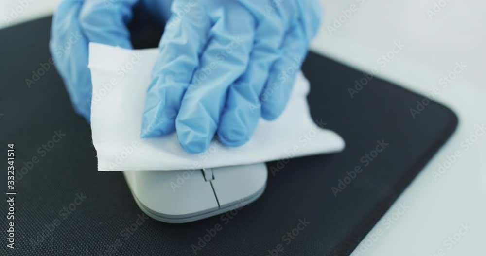 Office sanitizing wipe wiping mouse and mousepad with disinfecting wipes. Coronavirus COVID19