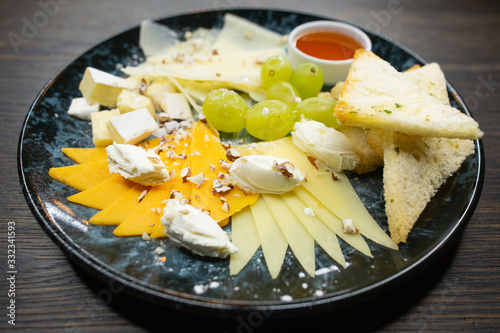 assorted cheese. thin sliced ​​cheese with grapes crispy croutons of white bread with honey and walnuts photo