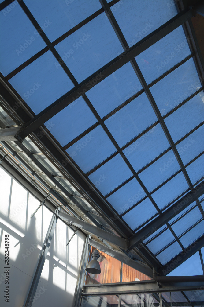 modern internal structure of glass roof construction with lockable windows sections, inside view of modern glass roof