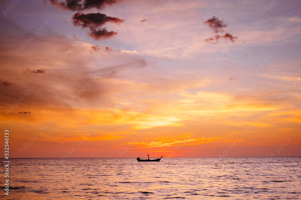 Serene sunset in Phuket, Thailand. Seascape, Indian ocean with boat silhouette on a horizon