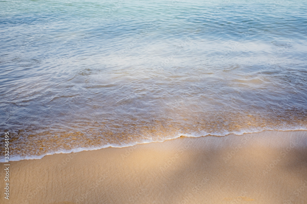 Calm beach, water edge and sand close up. Summer seaside background with a space for text.