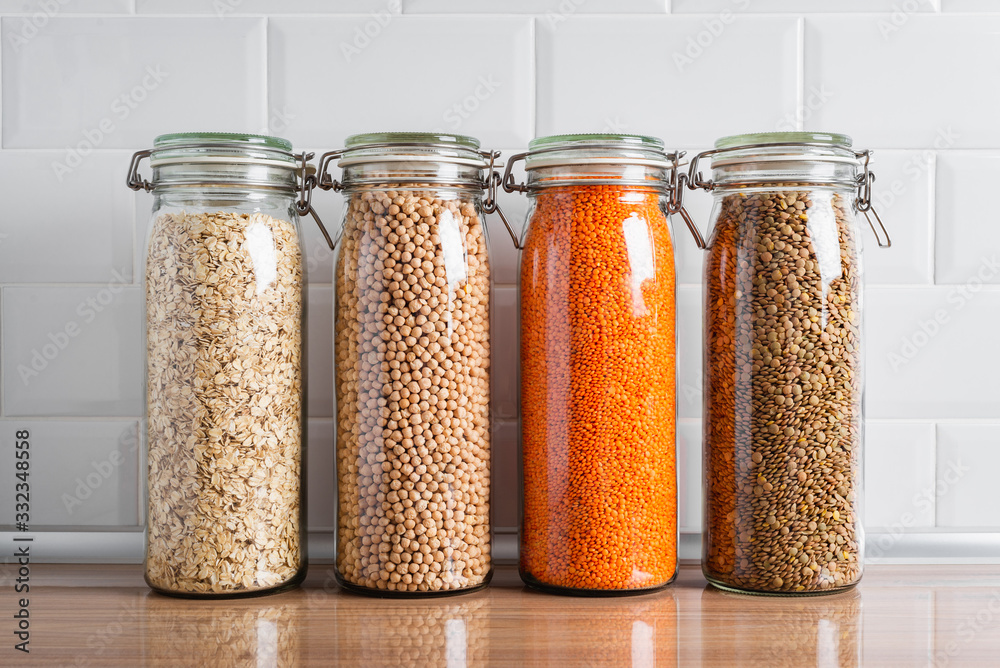Closeup of glass jars with dried legumes and grains on a kitchen counter Closeup of glass jars with dried legumes and grains on a kitchen counter