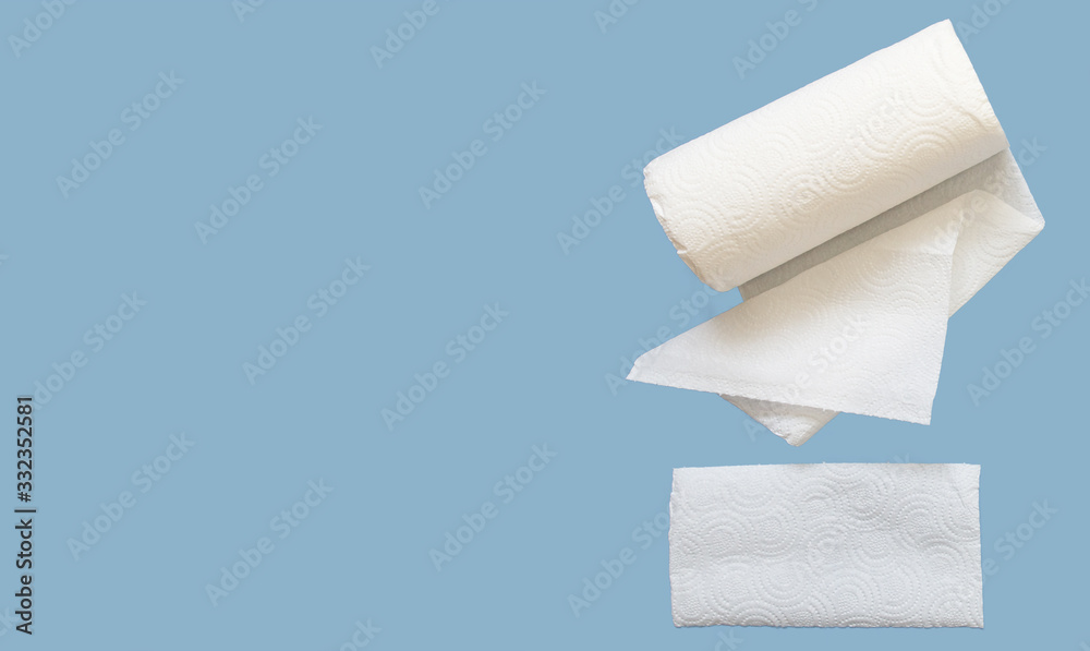 Fototapeta premium Paper towel. A roll of white paper towel on a sky blue background. The concept of personal hygiene, sanitation top view