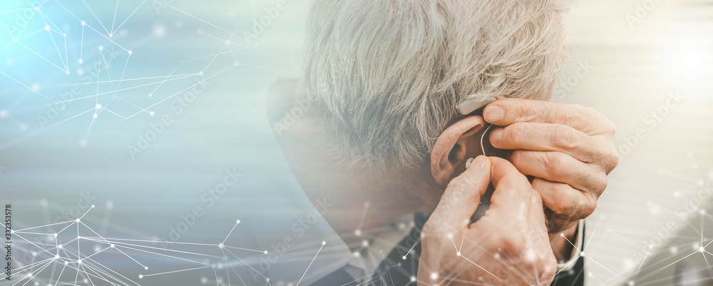 Фотография Man putting hearing aids; panoramic banner