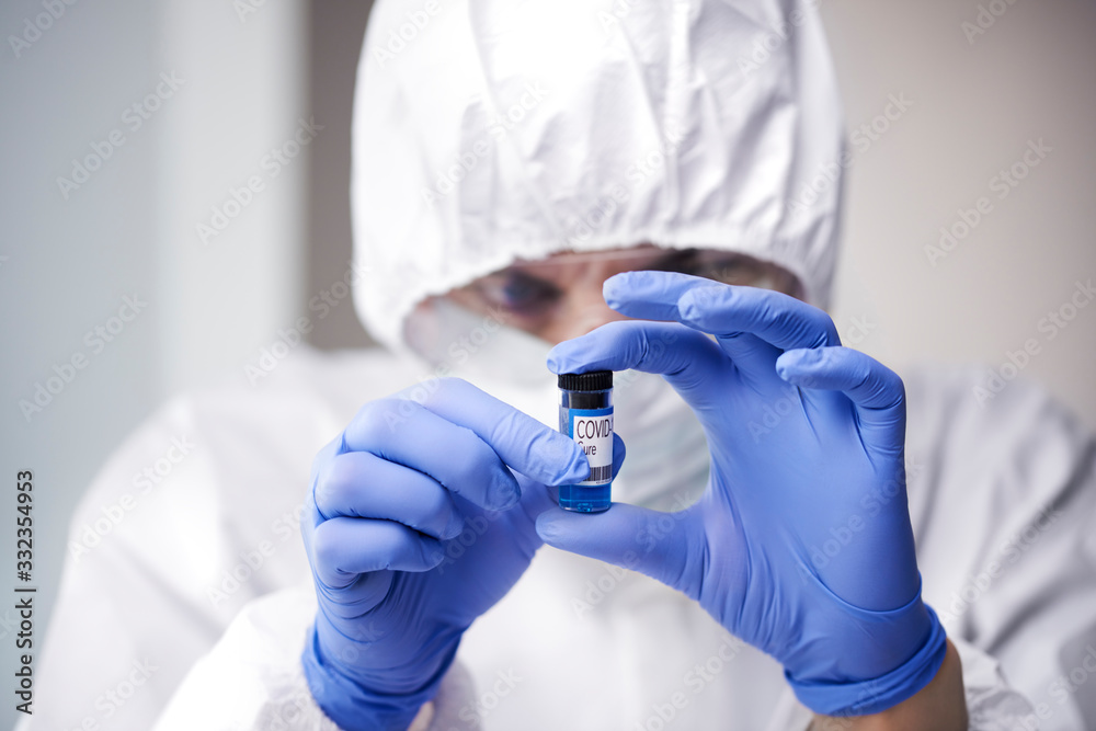 Technician holding an ampule with coronavirus cure Technician holding an ampule with coronavirus cure