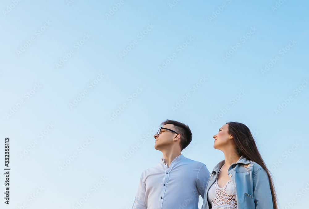 Loving couple on sky background.