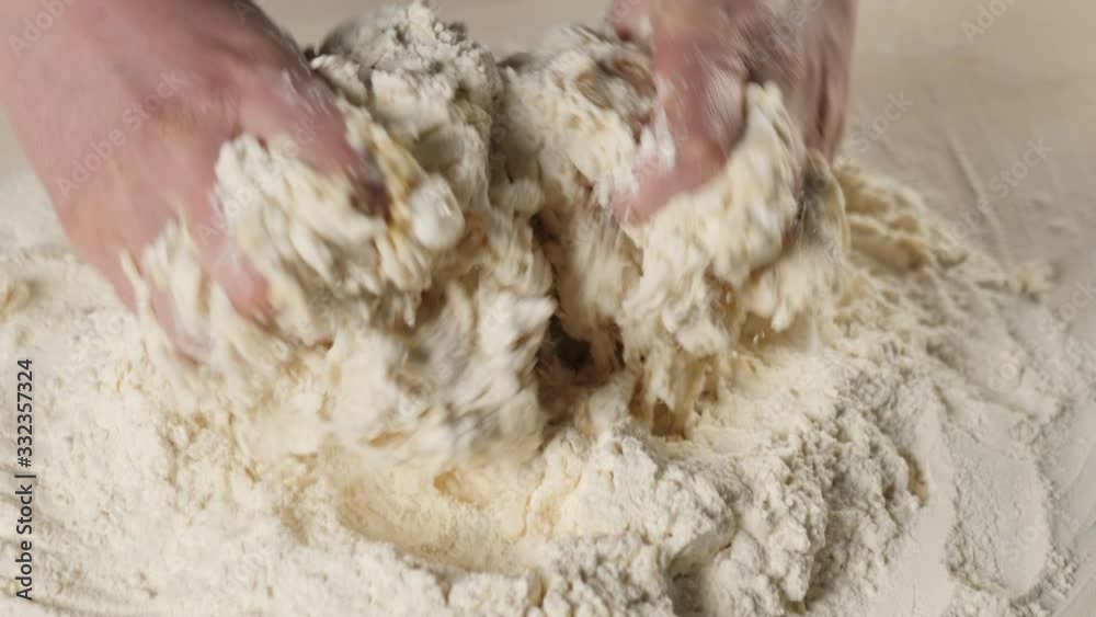 Professional baker mix flour with egg in a deepening in a heap of flour. Concept of dough kneading and cooking delicious pizza. Close up. 4K Professional baker mix flour with egg in a deepening in a heap of flour. Concept of dough kneading and cooking delicious pizza. Close up. 4K