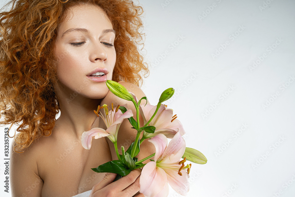 Calm Caucasian pretty girl with pink lilies
