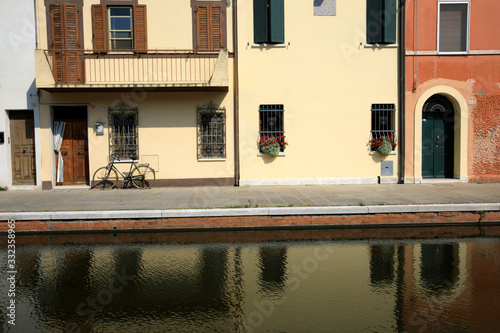 Comacchio (FE),  Italy - April 30, 2017: Houses in Comacchio village reflecting in the water, Delta Regional Park, Emilia Romagna, Italy photo