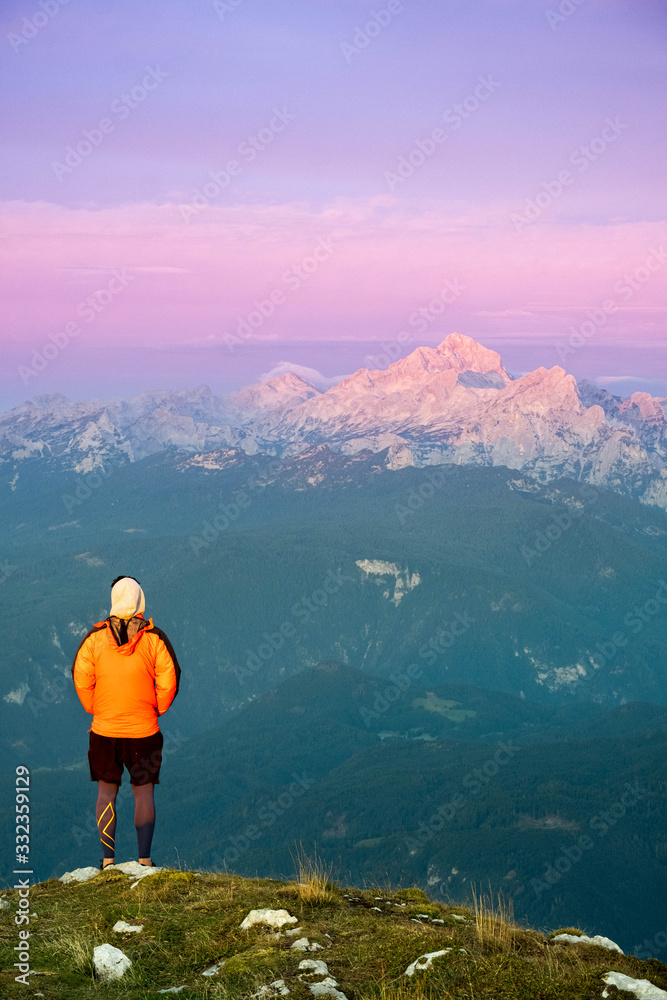 Person looking at the Julian alps on a mountain summit in Slovenia