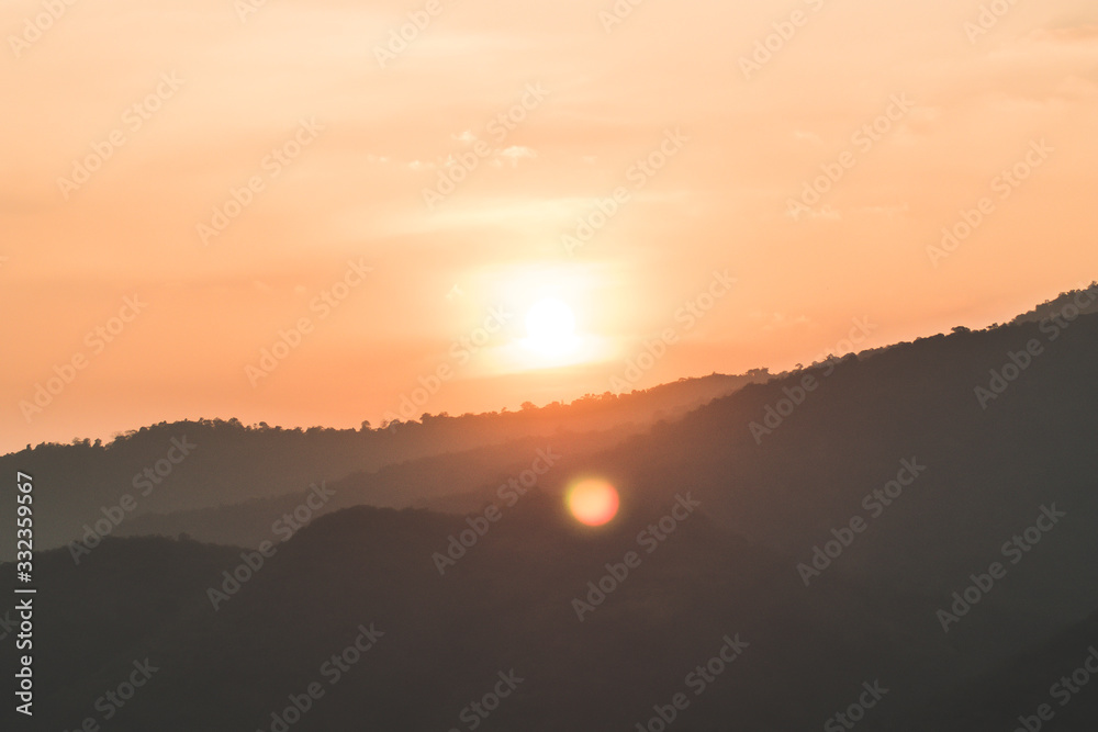 Fototapeta premium At sunset mountain landscape of silhouette. Sun Setting Behind Mountains. Sunset Over Mountain.