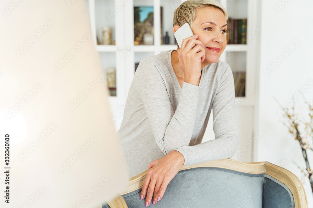 Fototapeta premium Pleased elegant woman talking on the phone