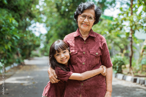Asian grandmother with grandchildren walking together in the park enjoying a vacation photo