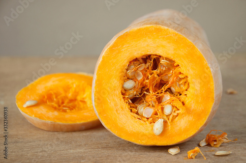 Raw ripe pumpkin sliced in rings lies on a wooden table. Product for preparing a healthy vegetarian diet. The basics of a healthy diet.