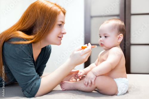 Medicine for baby. The kid receives medicine from a syringe. A mother gives a sick child medicine with a syringe.