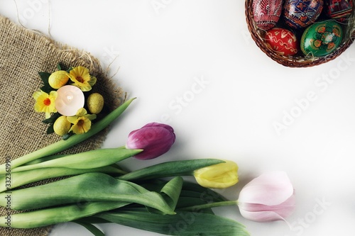 Obraz na płótnie Beautiful Eastern style flat lay with traditional painted eggs and tulips w salonie