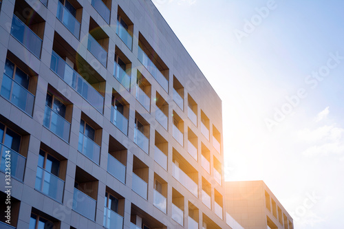 Modern apartment building exterior concept. Sunshine sun flare. 