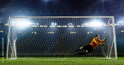 Goalkeeper is trying to save from a goal on an empty soccer stadium. No spectators on the tribunes. Stadium is made in 3d.