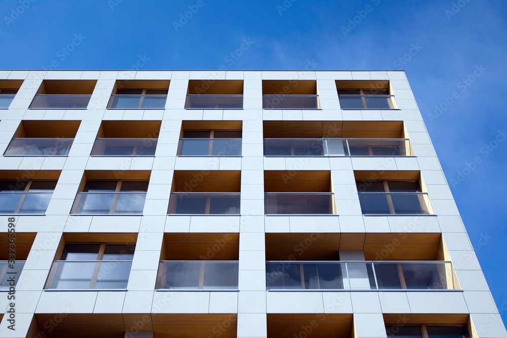 Exterior of new apartment buildings on a blue cloudy sky background. No people. Real estate business concept. Exterior of new apartment buildings on a blue cloudy sky background. No people. Real estate business concept.