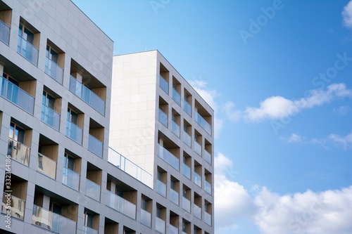 Exterior of new apartment buildings on a blue cloudy sky background. No people. Real estate business concept. © Grand Warszawski