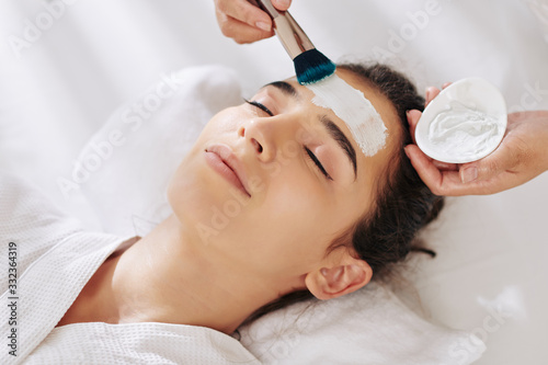 Close-up image of young woman getting moisturizing mask in beauty salon