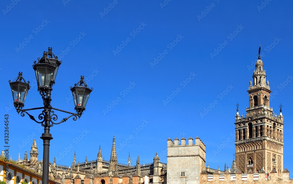 Giralda Tower and ornate wrought iron lamppost, Seville, Spain.