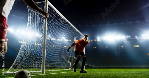 Goalkeeper is trying to save from a goal on an empty soccer stadium. No spectators on the tribunes. Stadium is made in 3d. © haizon