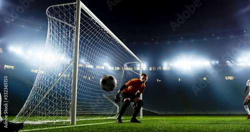 Goalkeeper is trying to save from a goal on an empty soccer stadium. No spectators on the tribunes. Stadium is made in 3d.