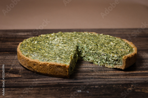 Appetizing kish with with spinach and cottage cheese on on a Wooden Table photo